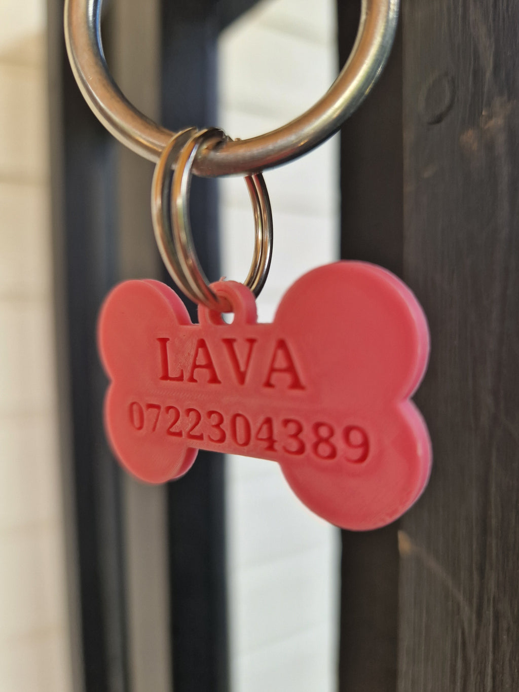 Personlig ID-bricka till hund med namn och telefonnummer i 3D-print i rosa färg. Exempel på ID-bricka